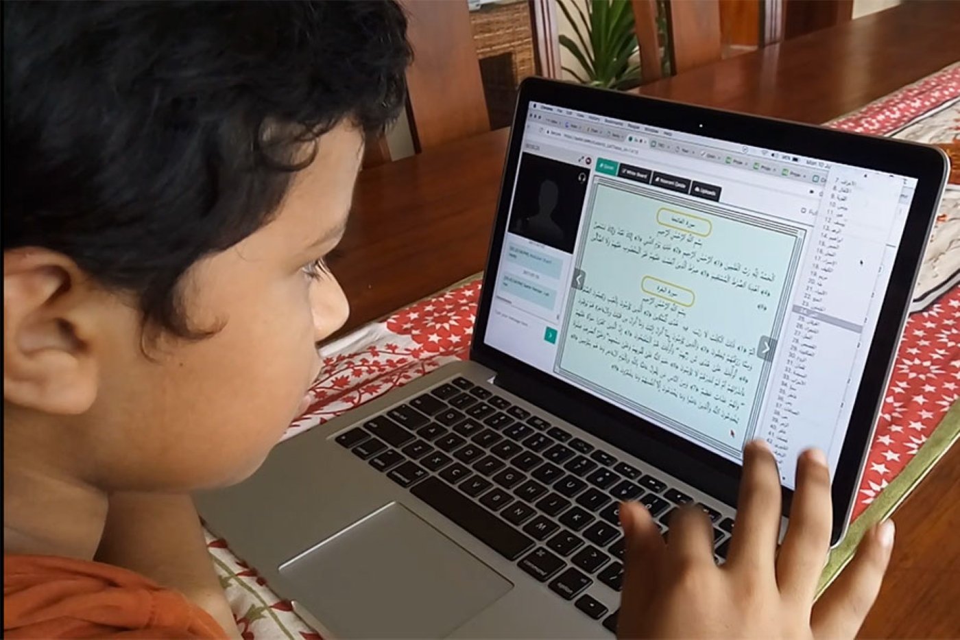 Child learning Quran online on a laptop